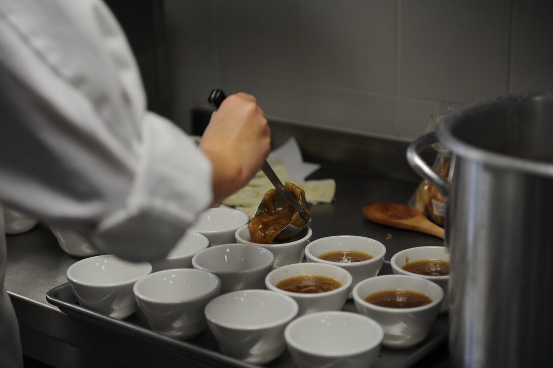 Baylee, a senior at Incirlik Unit school and Culinary Arts student, ladles French Onion soup into individual portions during class Feb. 6, 2015 at Incirlik Air Base, Turkey.  Students in class are taught food presentation as well as preparation. (U.S. Air Force photo by Tech. Sgt. Taylor Worley)