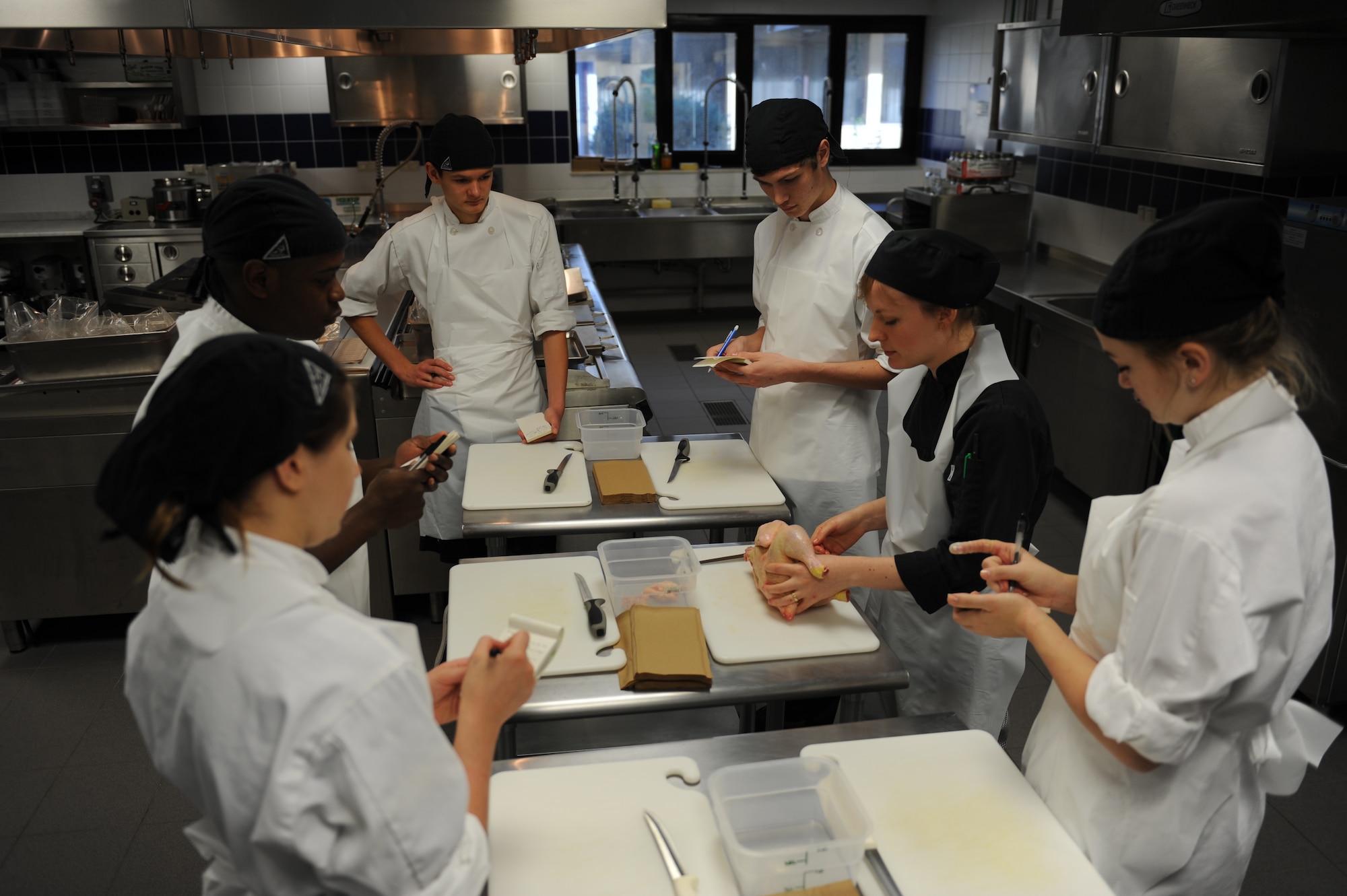 Chef Hannah McWilliams, Incirlik Unit School Culinary Arts teacher, demonstrates chicken fabrication to her students during class Jan. 23, 2015 at Incirlik Air Base, Turkey. Chicken fabrication is the process of separating a whole chicken into useable portions, using all parts of the bird with minimal waste. (U.S. photos by Tech. Sgt. Taylor Worley)