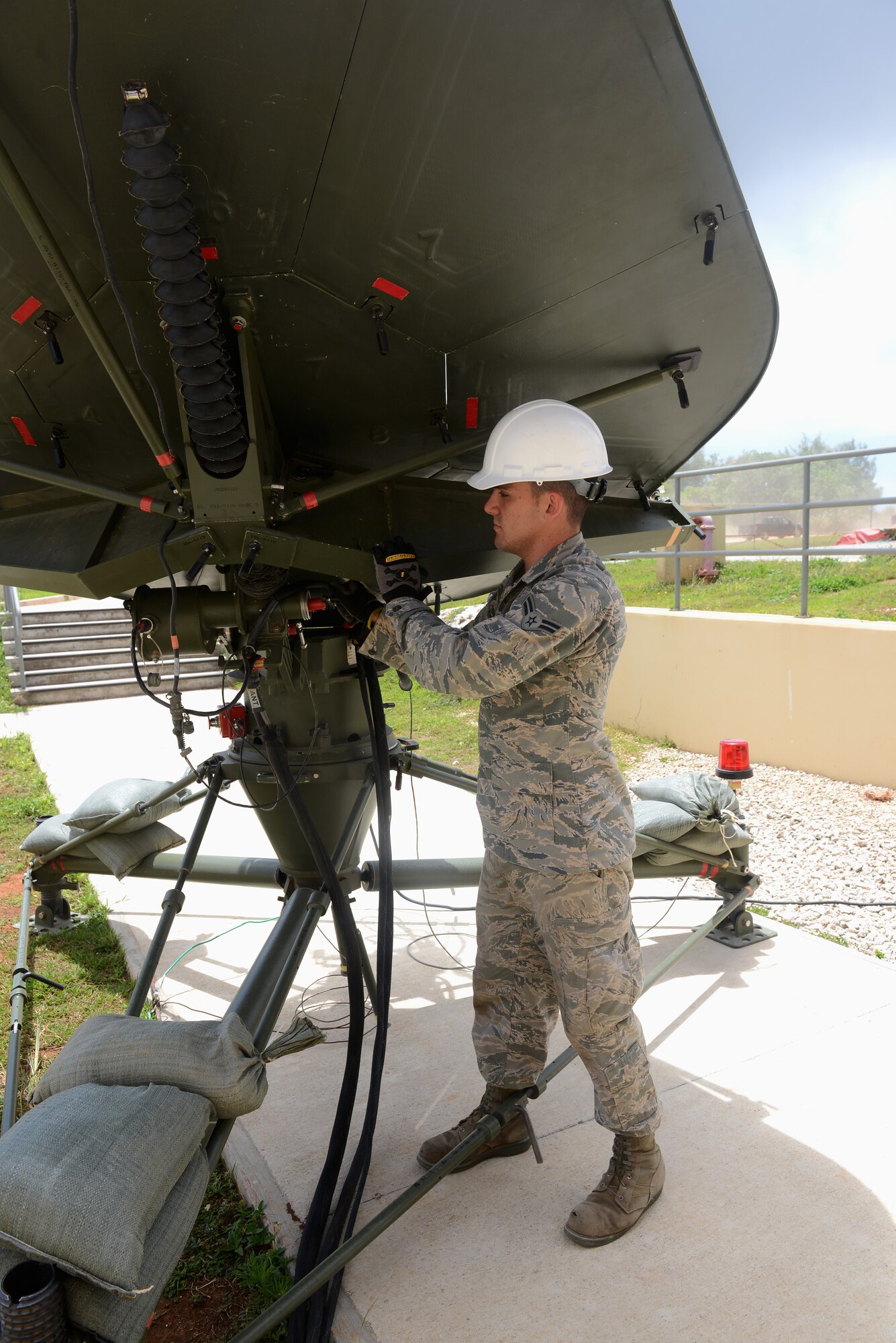 Airman 1st Class Brian Van Ackern, 644th Combat Communications Squadron radio frequency transmissions systems technician, adjusts a satellite terminal May 12, 2015, at Northwest Field, Guam. The unit is tasked with providing communication for a site that can range anywhere from 50 to 3,000 members, depending on operational needs. (U.S. Air Force photo by Airman 1st Class Arielle Vasquez/Released)