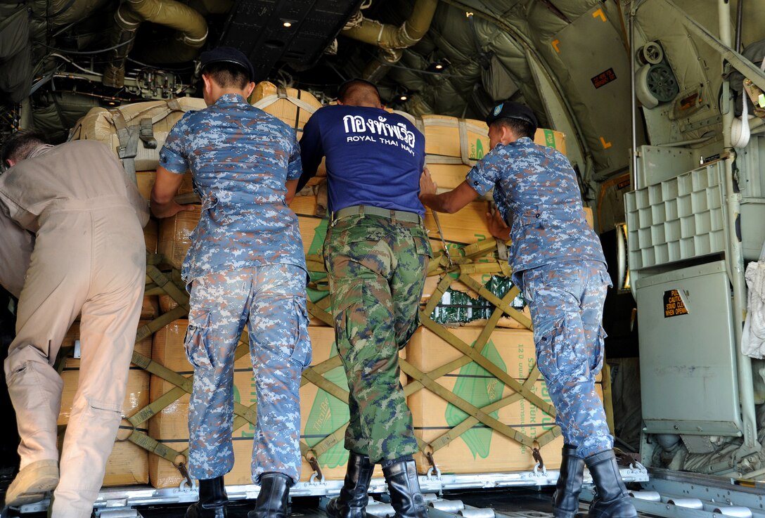 A U.S. Marine and Royal Thai Navy seamen load a pallet aboard a KC-130 ...