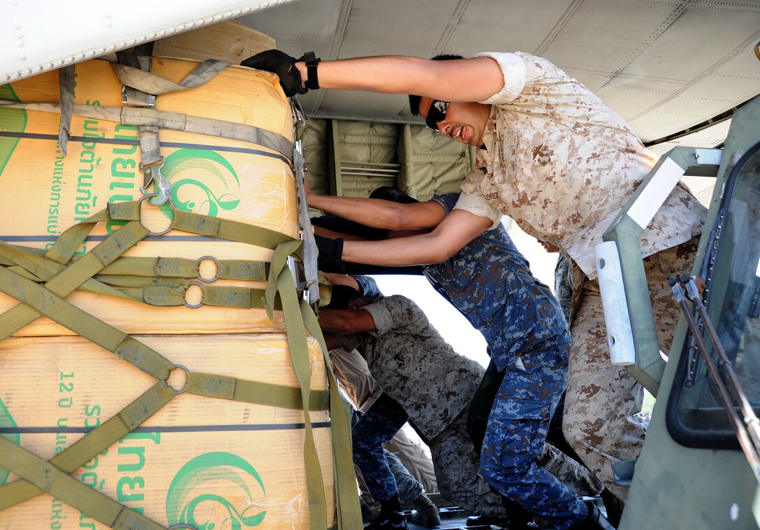 Thai and U.S. forces push a pallet of blankets onto a U.S. Marine KC-130 Hercules bound for Nepal at U-Tapao Royal Thai Naval Airfield, Thailand, May 21, 2015.