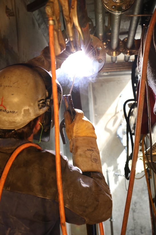 A Corps of Engineers maintenance worker uses an arc welder to weld new stainless steel piping at Chouteau Lock and Dam 17. Workers replaced more than 1700 feet of carbon steel piping with stainless steel pipe. Stainless steel is stronger and corrosion resistant.