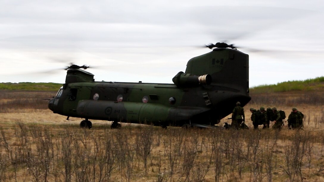 A Chinook with the Royal Canadian Air Force waits as Soldiers from the Canadian Army enter to be transported during Exercise Maple Resolve 2015 aboard Canadian Manoeuvre Training Center, Camp Wainwright, Alberta, Canada, May 16, 2015. The multi-national exercise, conducted annually by the Canadian Army, is a three-week, high-readiness validation exercise for Canadian Army elements designated for domestic or international operations. This year, the 1st Canadian Army Division and the 5th Canadian Mechanized Battle Group are being supported by the British 12th Armoured Infantry Brigade, various U.S. Army elements, and for the first time, members of  I MEF’s 1st ANGLICO who bring a unique capability to the table. (Photo by Cpl. Owen Kimbrel, U.S. Marine Corps)