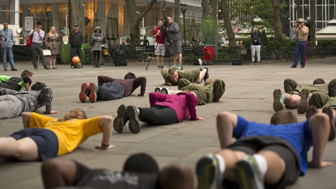 New York City residents joined Marines with 1st Battalion, 6th Marine Regiment in a more physical training session as a part of Marine Day at Bryant Park, New York City, May 21, 2015. Marines with Special-Purpose Marine Air Ground Task Force-New York showcase the capabilities of the Marine Corps both physically, mentally and technologically during Fleet Week New York. Fleet Week is an annual event that provides New York and surrounding area a chance to see the sea services capabilities.