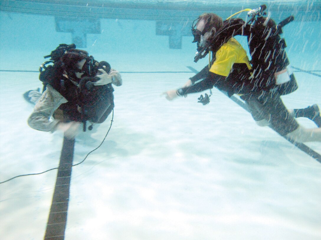 Gunnery Sgt. Zachary Burgart, left, dive project officer, and Ed Maziarski, dive locker manager, refresh their reconnaissance diving skills in the Ramer Hall pool Friday.
