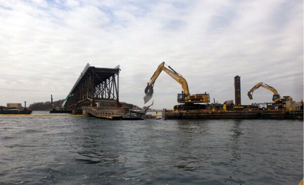 Contractor Walsh Construction removes and sorts bridge debris with barges and excavators during the demolition of the Long Island Bridge in Boston Harbor in Quincy and Boston, Massachusetts on April 6, 2015.