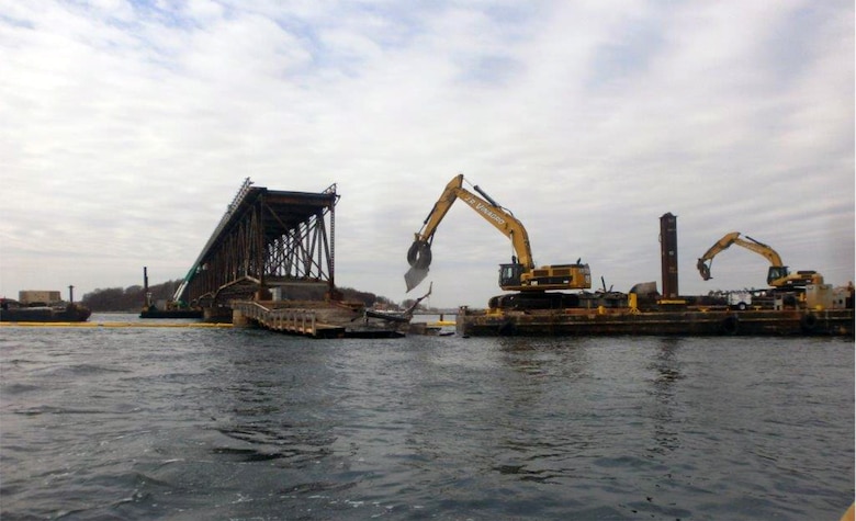 Contractor Walsh Construction removes and sorts bridge debris with barges and excavators during the demolition of the Long Island Bridge in Boston Harbor in Quincy and Boston, Massachusetts on April 6, 2015.