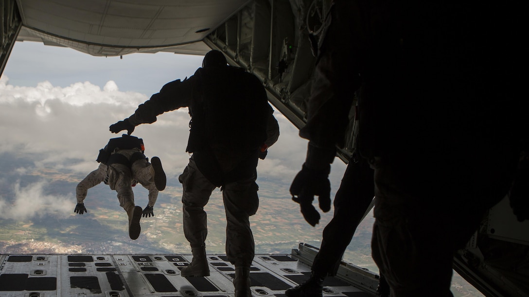 Paratroopers taking part in Exercise Lone Paratrooper jump out of a KC-130J from Special-Purpose Marine Air-Ground Task Force Crisis Response-Africa at Leόn Air Base, Spain, May 18, 2015. The multinational exercise integrated various paratroopers from different countries to simultaneously conduct High Altitude Low Opening and High Altitude High Opening jumps.