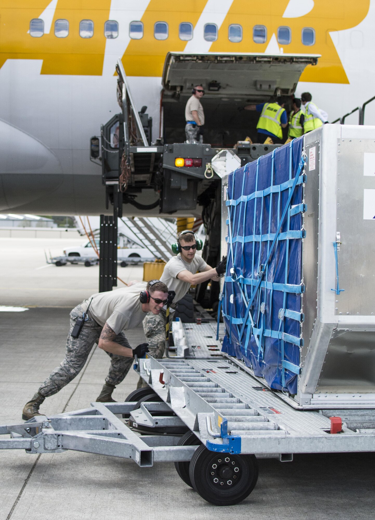 Airman 1st Class Patrick J. Lokhaiser (right), an air transportation specialist with the 32nd Aerial Port Squadron from Pittsburgh, and active-duty counterpart Senior Airman Scott Marvin, an air transportation specialist with the 721st APS here, unload a luggage pod on the flight line Ramstein Air Base, Germany, May 6, 2015. (U.S. Air Force photo by Staff Sgt. Brandy Grace)
