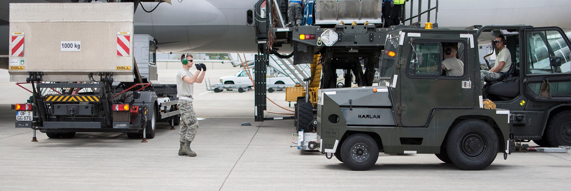 Airman 1st Class Patrick J. Lokhaiser, an air transportation specialist with 32nd Aerial Port Squadron, spots a warehouse tug on the flight line at Ramstein Air Base, Germany, May 6, 2015. Spotting ensures the safe completion of the aerial port mission. (U.S. Air Force photo by Staff Sgt. Brandy Grace)