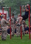 GySgt Gene E. Bradley, SNCOIC of Recruiting Sub Station North Indianapolis, counts a poolee's pull-ups in the rain during Recruiting Station Indianapolis' 2015 Statewide Pool Function in Indianapolis, Indiana May 16, 2015. The young men and woman train to become the next generation of America’s tough, smart and elite warriors by preparing their minds and bodies for the rigors of Marine Corps recruit training.