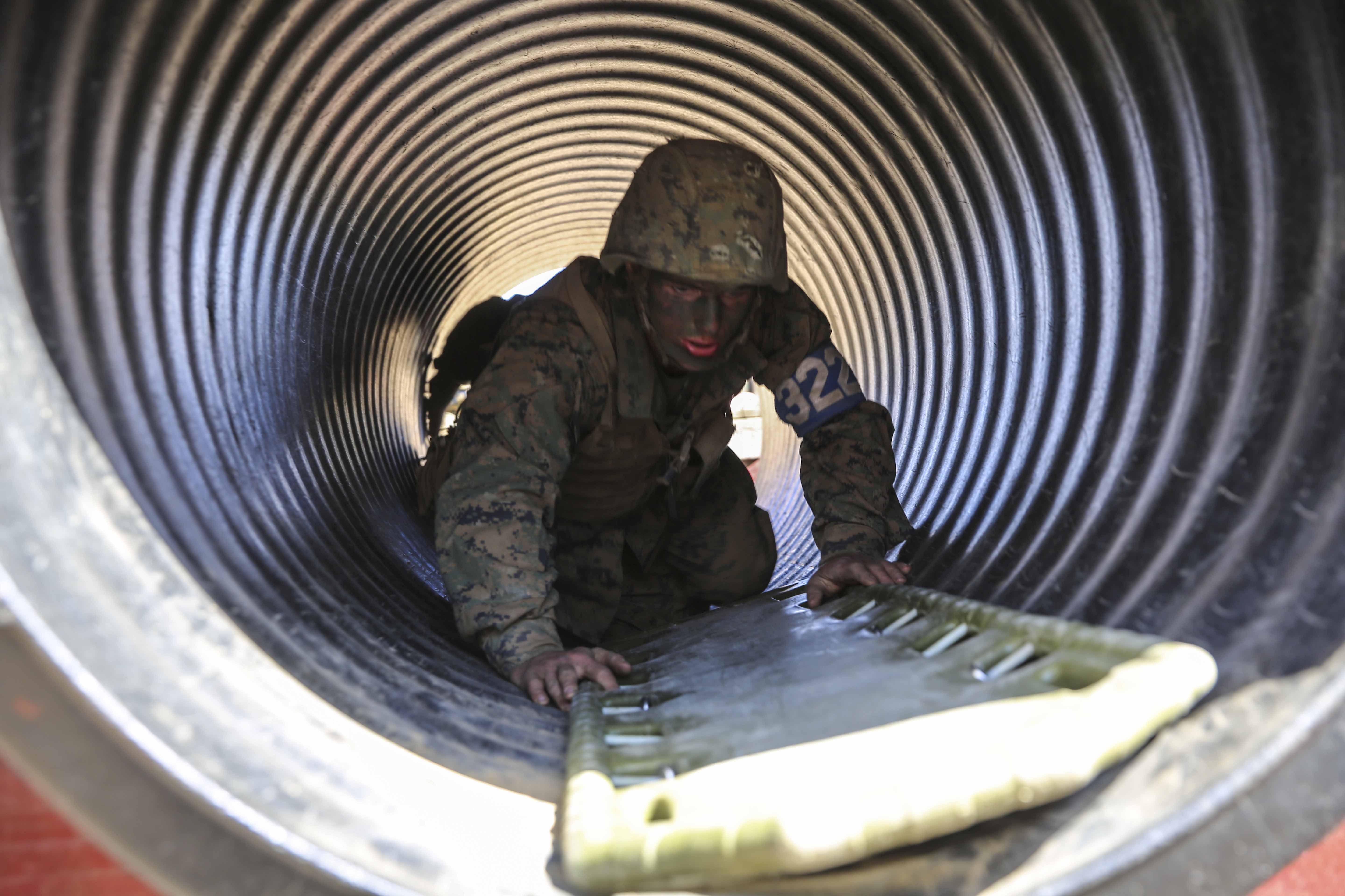 Private First Class Jonathan A. Uitvlugt, Kilo Company, 3rd Recruit Training Battalion, Platoon 3226, high crawls through an obstacle to retrieve a simulated injured Marine during the Crucible at Edson Range, Marine Corps Base Camp Pendleton, Calif., May 20. The purpose of the 12 Stalls exercise is to encourage one recruit to step up and provide leadership to his team. This gives the recruits an opportunity to develop a leader’s mindset when his team is looking up to him for the next set of orders. Uitvlugt is a 21-year-old Grand Rapids, Mich., native and was recruited from Recruit Station Lansing. Today, all males recruited from west of the Mississippi are trained at MCRD San Diego. The depot is responsible for training more than 16,000 recruits annually. Company K is scheduled to graduate from recruit training on May 29.