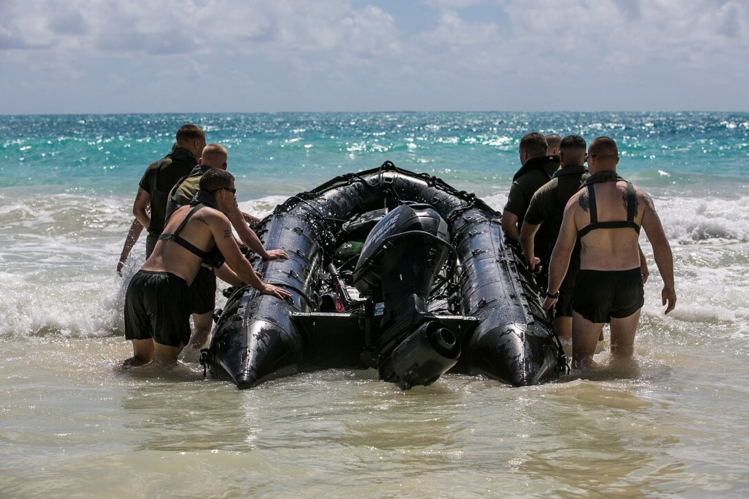 U.S. Marines with the 15th Marine Expeditionary Unit’s Maritime Raid Force carry a combat rubber raiding craft into the ocean aboard Bellows Air Force Station, Hawaii, May 15, 2015. These Marines practiced broaching the CRRC, which they would do if it was filled with too much water and needed to be flipped over. (U.S. Marine Corps photo by Cpl. Anna Albrecht/Released)