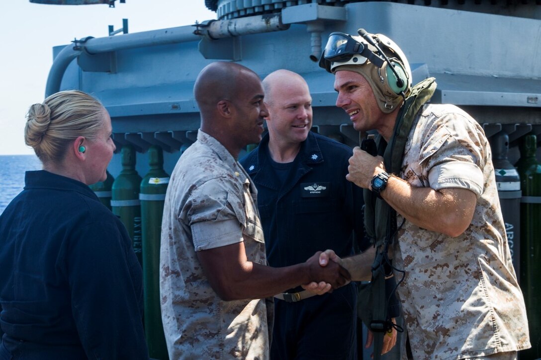 U.S. Marine Col. Vance L. Cryer, right, greets Maj. Andre Ingram during a visit to the USS Rushmore (LSD 47) at sea in the Pacific Ocean, May 16, 2015. Cryer is the commanding officer of the 15th Marine Expeditionary Unit and Ingram is the executive officer for Combat Logistics Battalion 15, 15th MEU. While on ship, Cryer addressed the Marines with Kilo Company, Battalion Landing Team 3rd Battalion, 1st Marine Regiment, 15th MEU and as well as the Marines and Sailors with CLB-15 to stress the importance of their mission while deployed. (U.S. Marine Corps photo by Sgt. Emmanuel Ramos/Released)