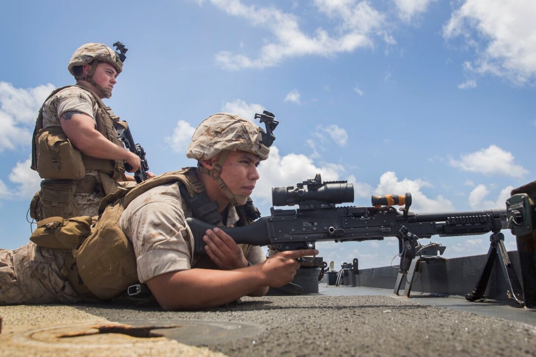 U.S. Marines Pfc. Leonel Arellano, right, and Lance Cpl. Jonathon Workman man their position during small-craft action team rehearsals aboard the USS Rushmore (LSD 47) at sea in the Pacific Ocean, May 16, 2015. Arellano is a machine gunner, and Workman is a team leader with Kilo Company, Battalion Landing Team 3rd Battalion, 1st Marine Regiment, 15th Marine Expeditionary Unit. SCAT drills prepare Marines with the 15th MEU for potential threats they may encounter while deployed. (U.S. Marine Corps photo by Sgt. Emmanuel Ramos/Released)