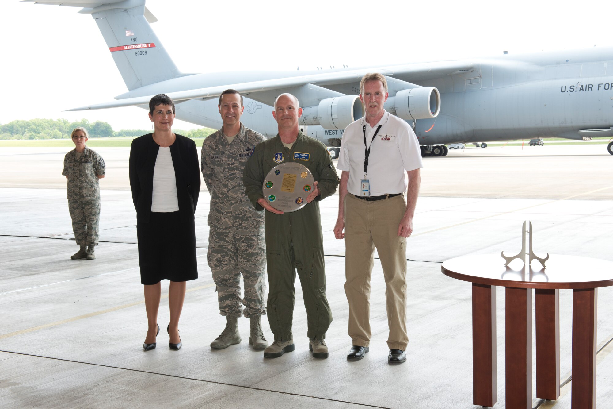 Col. Shaun Perkowski, second from right, 167th Airlift Wing commander, and Chief Master Sgt. Ron Glazer, 167th Airlift Wing command chief, accepted a plaque from Lockheed Martin representatives, Kim Mazur, left, program director for Lockheed Martin, and Chuck LaFavre, Lockheed Martin Martinsburg C-5 systems engineer during a ceremony marking the end of a 52 year partnership between the 167th Airlift Wing and Lockheed Martin at the Martinsburg, W.Va. unit, May 19. The wing is in conversion from C-5 Galaxy aircraft to C-17 Globemaster III aircraft. The last C-5 assigned to wing departed May 20 for the 309th Aerospace Maintenance and Regeneration Group at Davis-Monthan Air Force Base. (photo by Master Sgt. Emily Beightol-Deyerle/released)