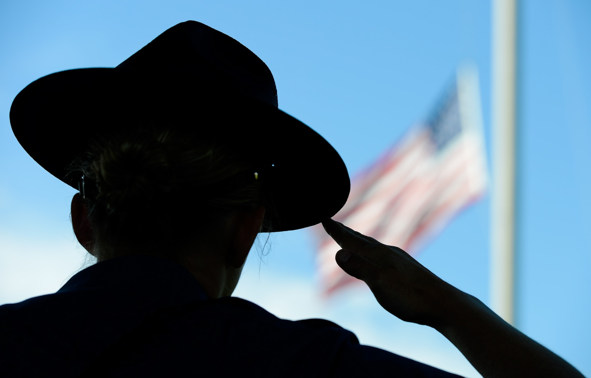Trooper Christine Armstrong, Delaware State Police, salutes the American flag as it is lowered during the formal retreat ceremony marking the end of Police Week May 15, 2015, at Dover Air Force Base, Del. Armstrong represented the Delaware State Police in a formation of law-enforcement officers from Dover AFB and other regional agencies. (U.S. Air Force photo/Greg L. Davis)