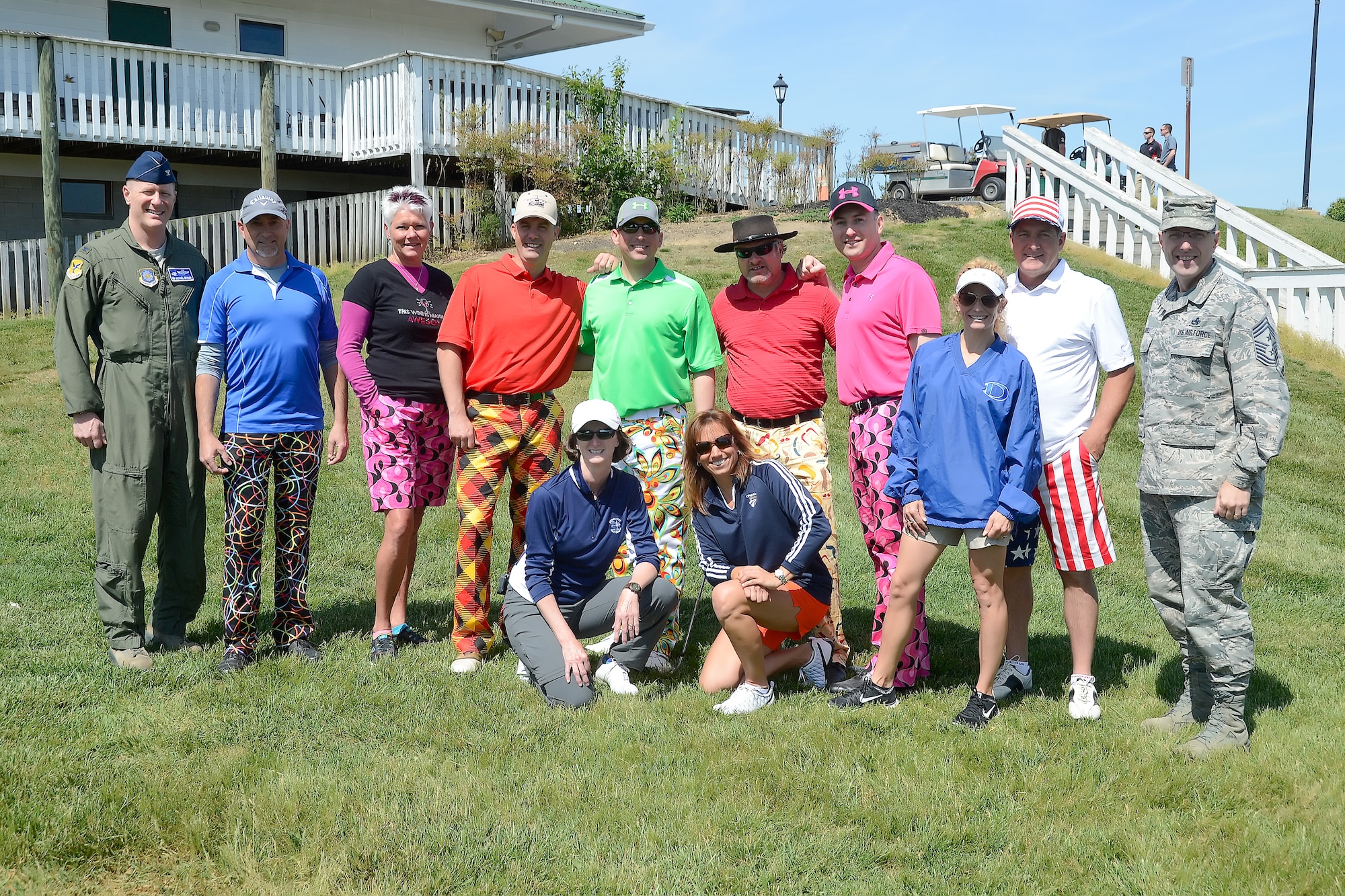 Col. Michael Grismer, 436th Airlift Wing commander, left, and Chief Master Sgt. Stanley Cadell, 436th AW command chief, right, pose with participants wearing colorful golf attire prior to the start of the semi-annual Dover Bluesuiters Golf Tournament May 14, 2015, at Jonathan???s Landing Golf Course in Magnolia, Del. Key military leaders from Dover Air Force Base were paired with local civic and business leaders for the tournament as part of Dover AFB's robust community outreach program. (U.S. Air Force photo/Greg L. Davis)