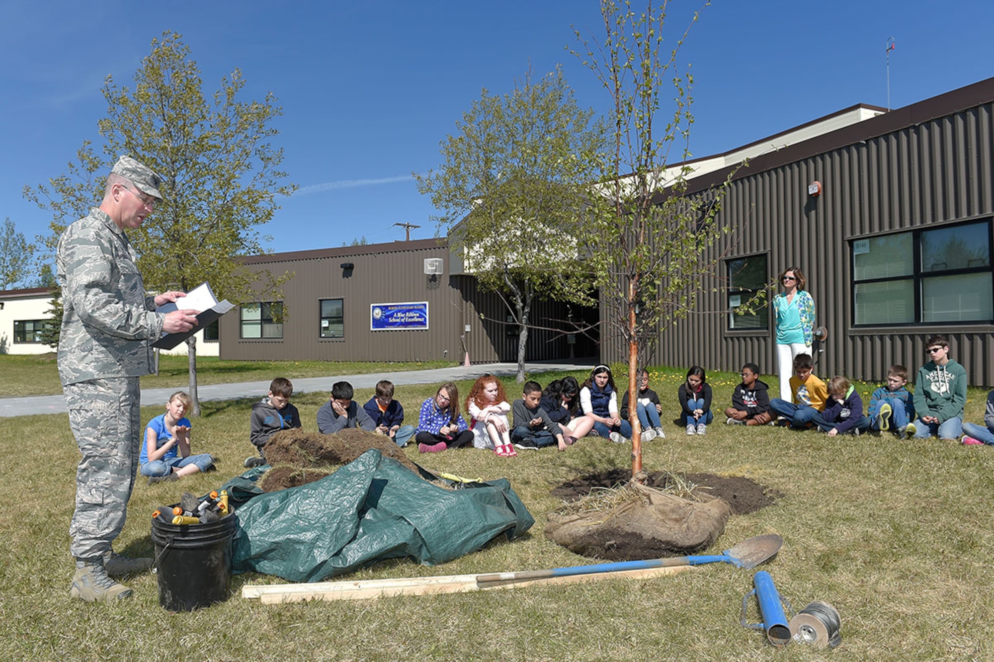Aurora Elementary School 5th grade students celebrate Arbor Day by planting a tree on Joint Base Elmendorf-Richardson May 18. 673d Air Base Wing and JBER commander Air Force Col. Brian Bruckbauer, Alaska State Community Forester Stephen Nickels and JBER ecologist Charlene Johnson were on hand to deliver remarks and information regarding Alaska trees and the importance of environmental conservation. (U.S. Air Force photos/Alejandro Pena)