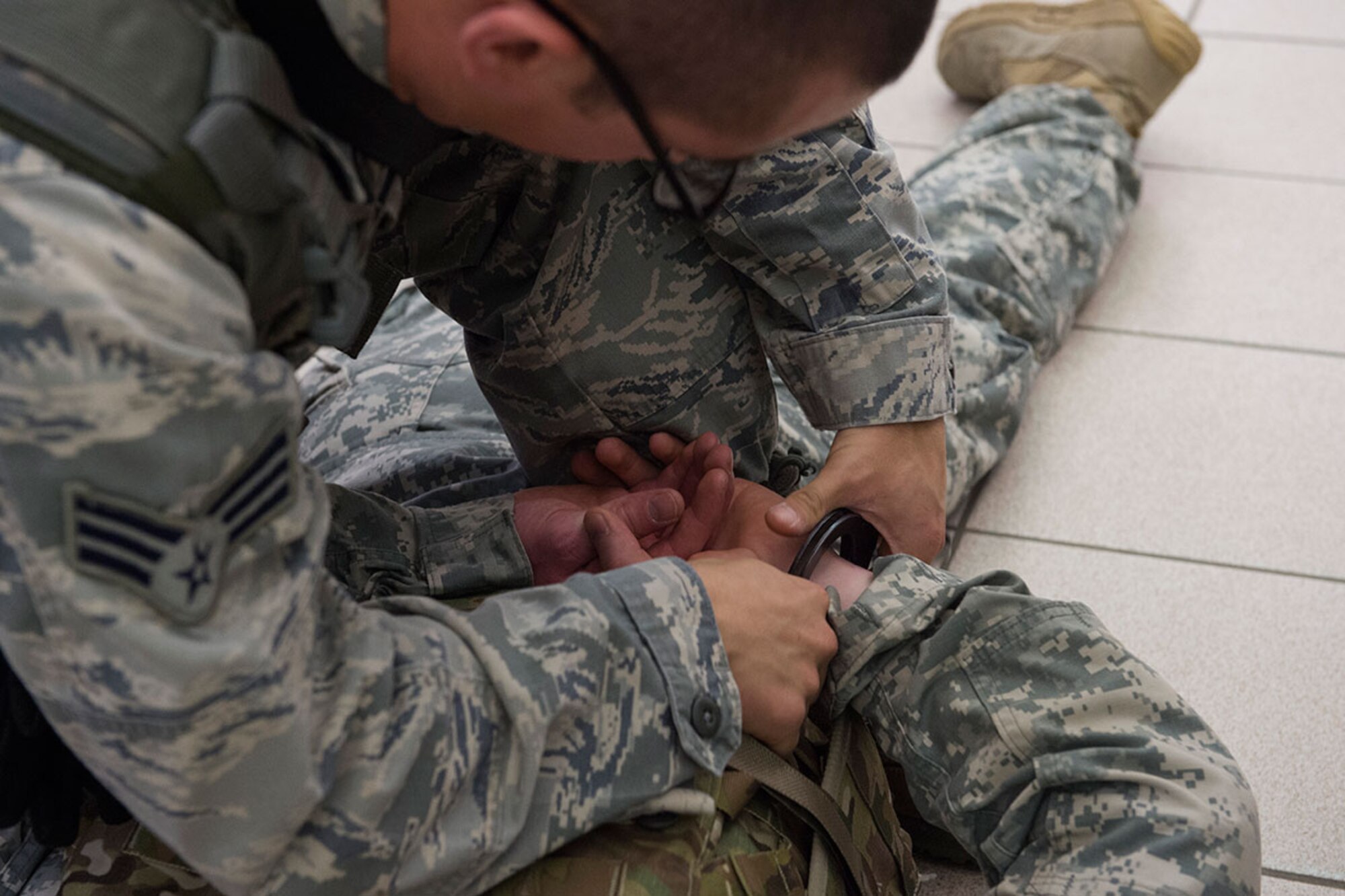 U.S. Air Force Senior Airman Sean Pender, left, practices restraining U.S. Army Sgt. Thomas Kruse, while conducting high risk response training on Joint Base Elmendorf-Richardson, Alaska, May 15, 2015. Pender and Kruse are respectively assigned to the 673rd Security Forces Squadron and the 545th Military Police Company. (U.S. Air Force photo/Alejandro Pena)