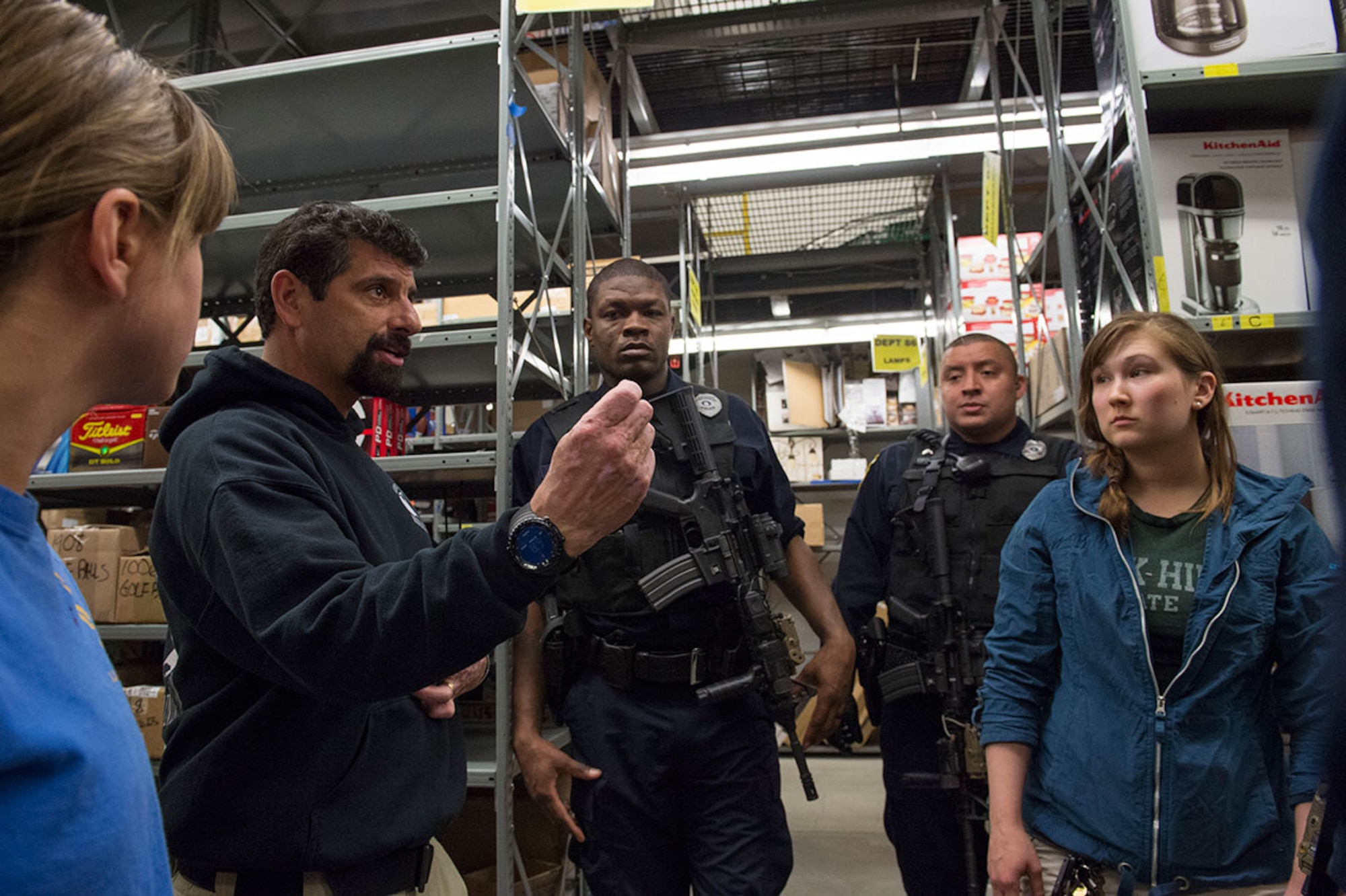 John Knipe, right, a high risk response instructor, debriefs Joint Base Elmendorf-Richardson police officers and role players while conducting active shooter training at the base exchange on JBER, Alaska, May 15, 2015. Pacific Air Forces High Risk Response Training is a project that provides security forces personnel with an intensive course based in real-life scenarios emphasizing effective tactics to eliminate active shooters and other threats. (U.S. Air Force photo/Alejandro Pena)