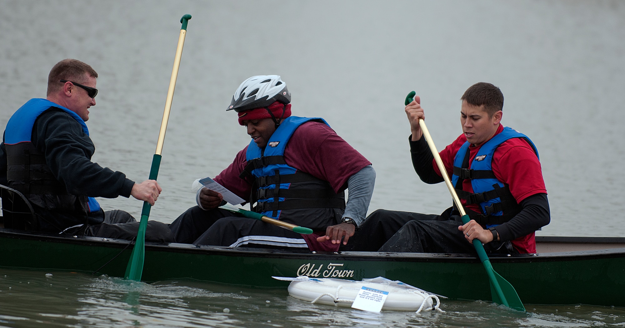 Tech. Sgt. Ernest Poore, 20th Air Force, reads the next clue as Master Sgt. Charles Pearce and Tech. Sgt. Robert Trotter, 20th AF, paddle back to the shore of F.E. Warren Air Force Base, Wyo.’s, base lake May 20, 2015, during the 90th Force Support Squadron’s Amazing Race competition. The race was held as part of Warren’s fitness month. (U.S. Air Force photo by Airman 1st Class Brandon Valle)