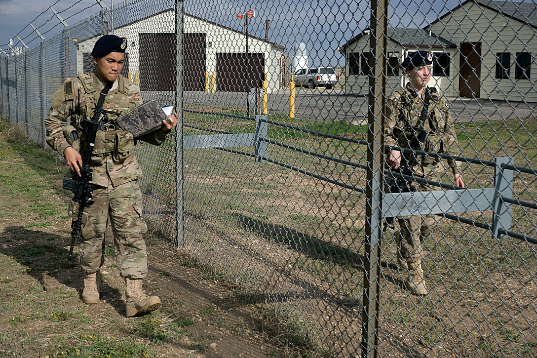 Airman 1st Class Christian Watson and Airman Katie Pluim, 90th Missile Security Forces Squadron, perform a security sweep around a missile alert facility April 27, 2015. Watson overcame many obstacles, including a language barrier, to succeed and grow as a security forces Airman. (U.S. Air Force photo by Lan Kim)