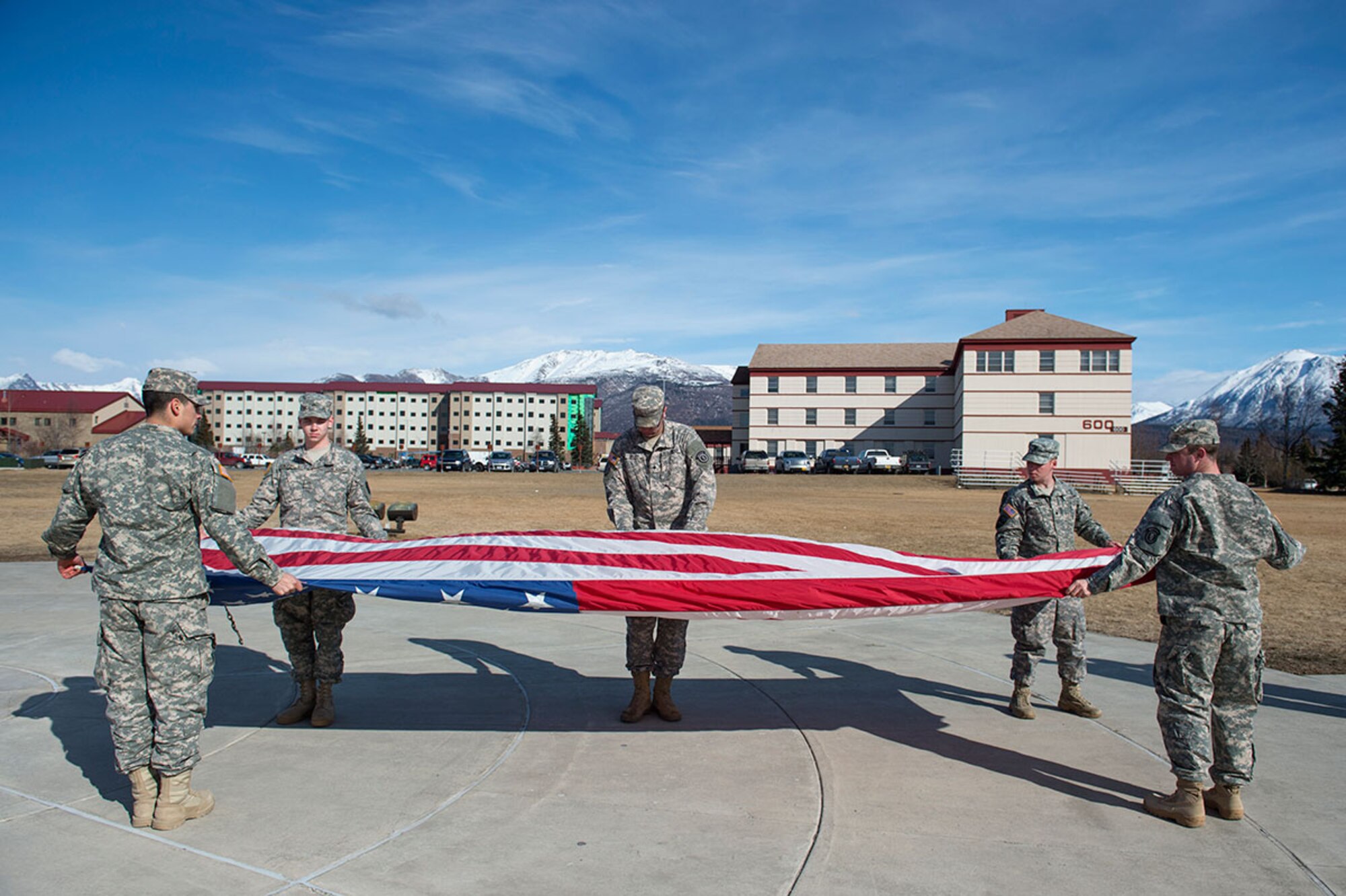 A flag detail of Soldiers assigned to the 109th Transportation Company, 17th Combat Sustainment Support Battalion, 2nd Engineer Brigade, U.S. Army Alaska, folds the colors after retreat on Pershing Field at JBER April 21. Retreat signifies the end to the official duty day on U.S. military installations. (U.S. Air Force photo/Alejandro Pena)