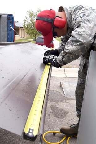 Airman 1st Class Christian Calderon, 819th RED HORSE Squadron structures shop, measures and marks wall panels May 20, 2015, at Malmstrom Air Force Base, Mont. RED HORSE's major wartime responsibility is to provide a highly mobile, rapidly deployable, civil engineering response force that is self-sufficient to perform heavy damage repair required for recovery of critical Air Force facilities and utility systems, and aircraft launch and recovery. (U.S. Air Force photo/Chris Willis)