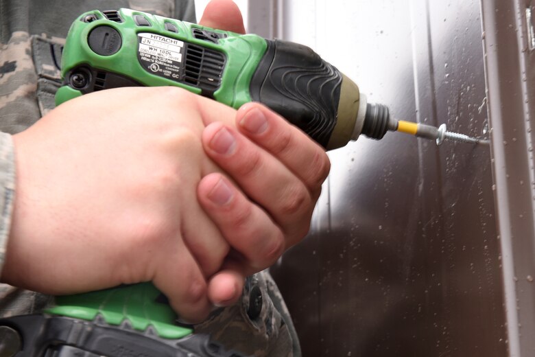 An Airman from the 819th RED HORSE Squadron structures shop drills in new panels for a storage shed May 20, 2015, at Malmstrom Air Force Base, Mont. RED HORSE, or Rapid Engineer Deployable, Heavy Operational Repair Squadron, Engineer squadrons provide the Air Force with a highly mobile civil engineering response force to support contingency and special operations worldwide. (U.S. Air Force photo/Chris Willis)