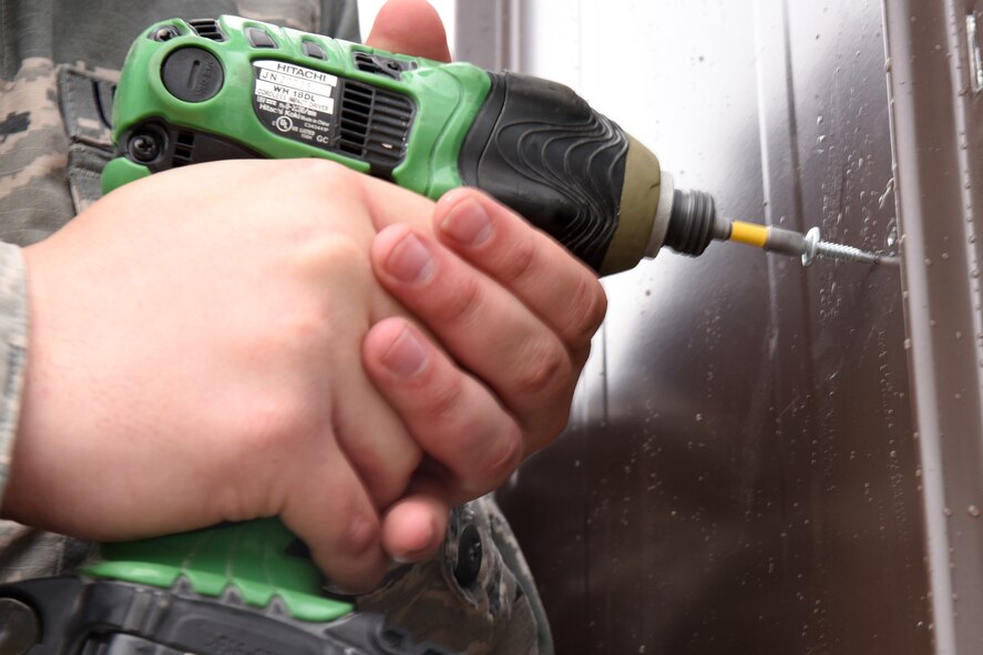 An Airman from the 819th RED HORSE Squadron structures shop drills in new panels for a storage shed May 20, 2015, at Malmstrom Air Force Base, Mont. RED HORSE, or Rapid Engineer Deployable, Heavy Operational Repair Squadron, Engineer squadrons provide the Air Force with a highly mobile civil engineering response force to support contingency and special operations worldwide. (U.S. Air Force photo/Chris Willis)