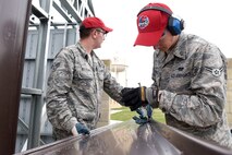 Senior Airman Stephen Kostecka, and Airman 1st Class Adam Kresge, 819th RED HORSE Squadron structures shop, cut siding panels for a storage shed May 20, 2015, at Malmstrom Air Force Base, Mont. RED HORSE's major wartime responsibility is to provide a highly mobile, rapidly deployable, civil engineering response force that is self-sufficient to perform heavy damage repair required for recovery of critical Air Force facilities and utility systems, and aircraft launch and recovery. (U.S. Air Force photo/Chris Willis)