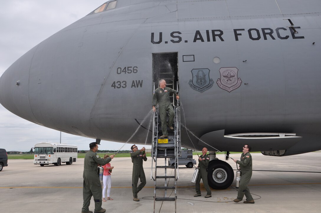 Members of the 433rd Airlift Wing greet Col. Jimmie "Pat" Brooks, 356th Airlift Squadron commander with a spray of water after his fini flight, May 21, 2015, at Joint Base San Antonio-Lackland, Texas. Brooks leaves the "Alamo Wing" to serve as the 908th Airlift Wing vice commander at Maxwell Air Force Base, Alabama.