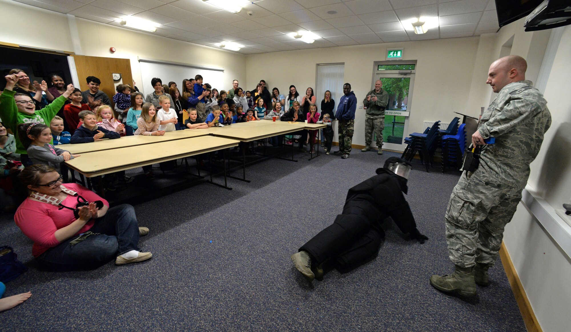 U.S. Air Force Staff Sgt. Daniel Montgomery, right, 100th Security Forces Squadron trainer from Frankfort, Ohio, conducts a taser demonstration on Senior Airman Nicholas Zimmer, 100th SFS trainer from Haveluck, N.C., during a Hearts Apart event, May 20, 2015, on RAF Mildenhall, England. The 100th SFS hosted the monthly event which helps bring Team Mildenhall families of deployed Airmen closer during times of separation. (U.S. Air Force photo by Senior Airman Christine Halan/Released)