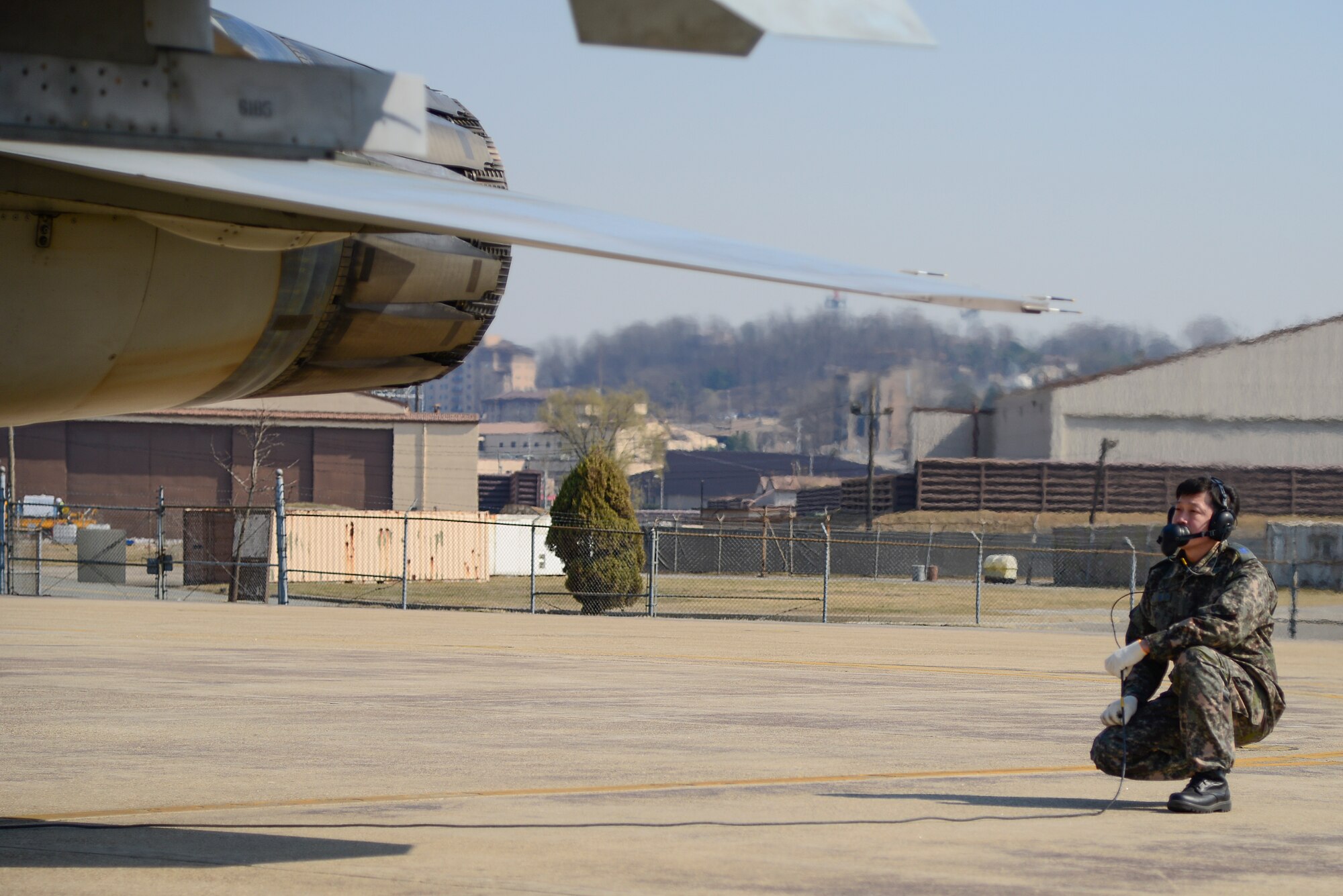A Republic of Korea air force crew chief  performs pre-flight checks during Buddy Wing 15-3 March 25, 2015, at Osan Air Base, ROK. During Buddy Wing, members from each air force share tactics and procedures to become familiar with how each other work during flying missions. (U.S. Air Force photo by Senior Airman Matthew Lancaster)