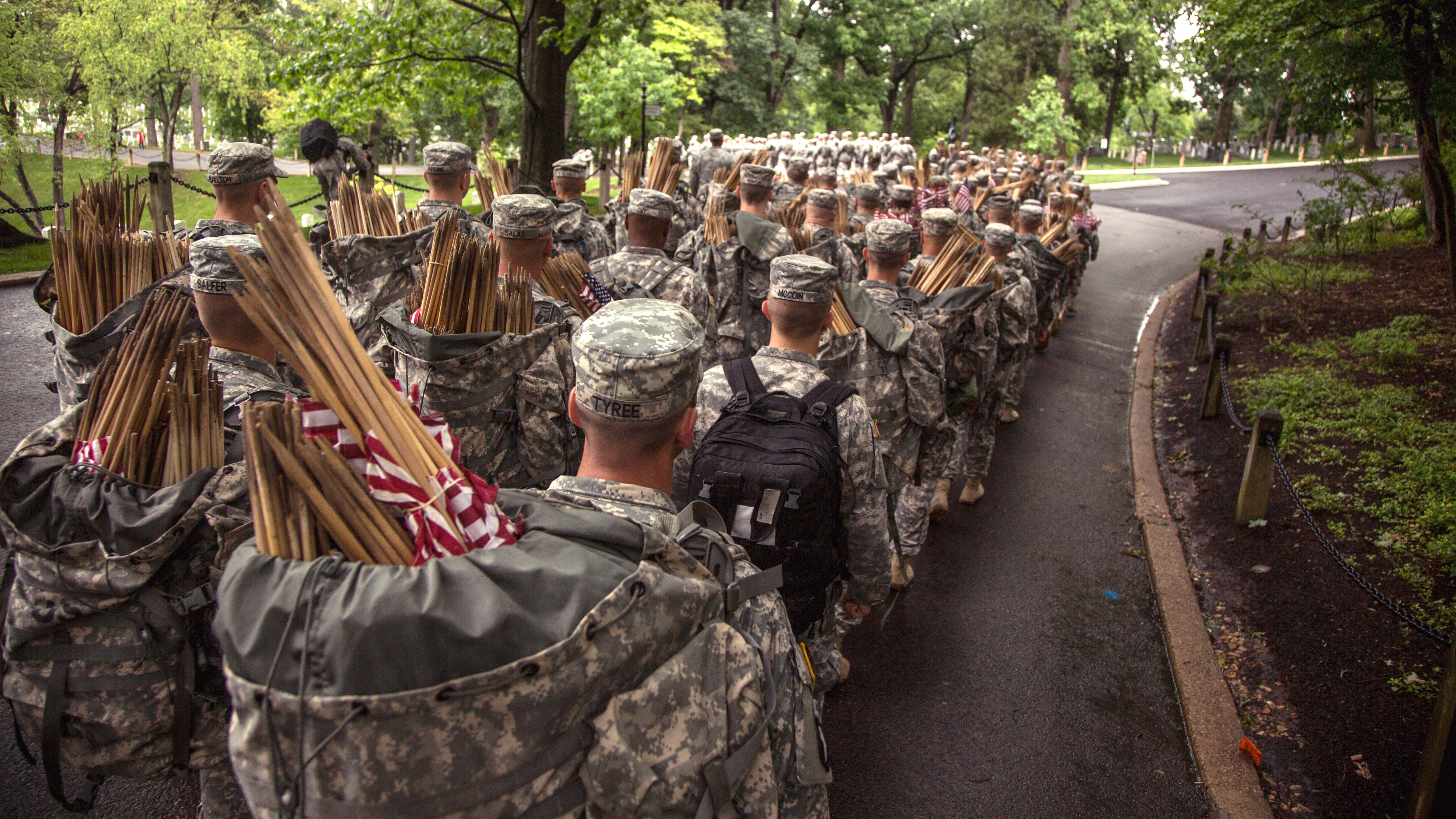 Carrying Bundles Of Small Amercian Flags In Backpacks Soldiers March Out To Their Assigned Sections During
