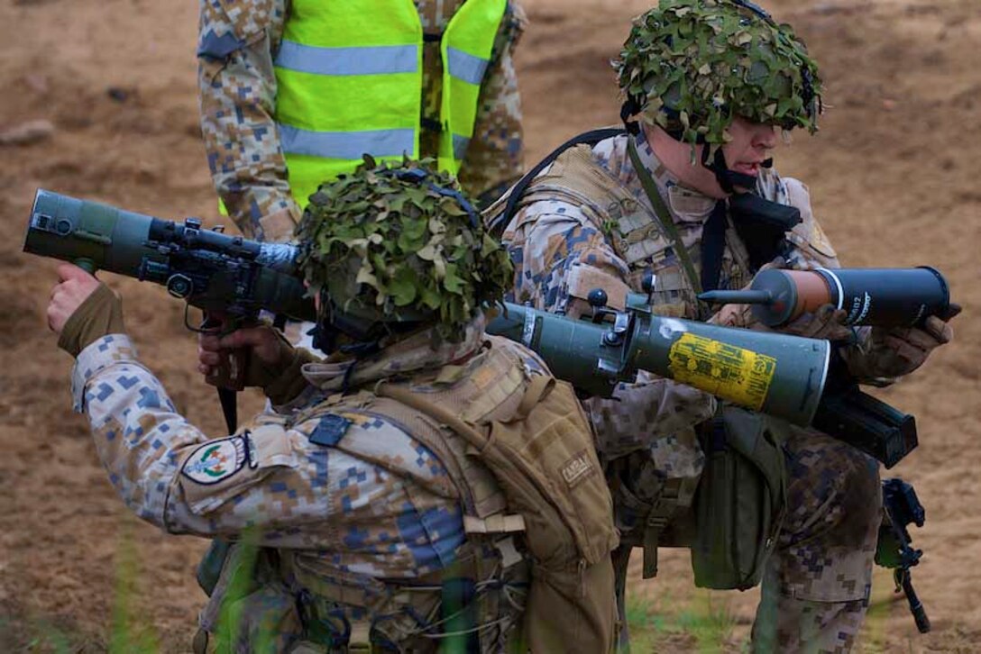 A soldier assigned to the 1st Infantry Battalion, Latvian Land Forces Infantry Brigade loads a round into a Carl Gustaf M2CG recoilless rifle during squad movement procedures with U.S. soldiers during joint gunnery training in Adazi, Latvia, May 21, 2015. 