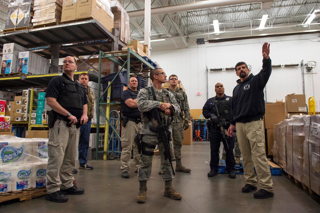 John Knipe, right, a high risk response instructor, briefs U.S. airmen and civilian law enforcement members before conducting active shooter training at the base exchange on Joint Base Elmendorf-Richardson, Alaska, May 15, 2015.