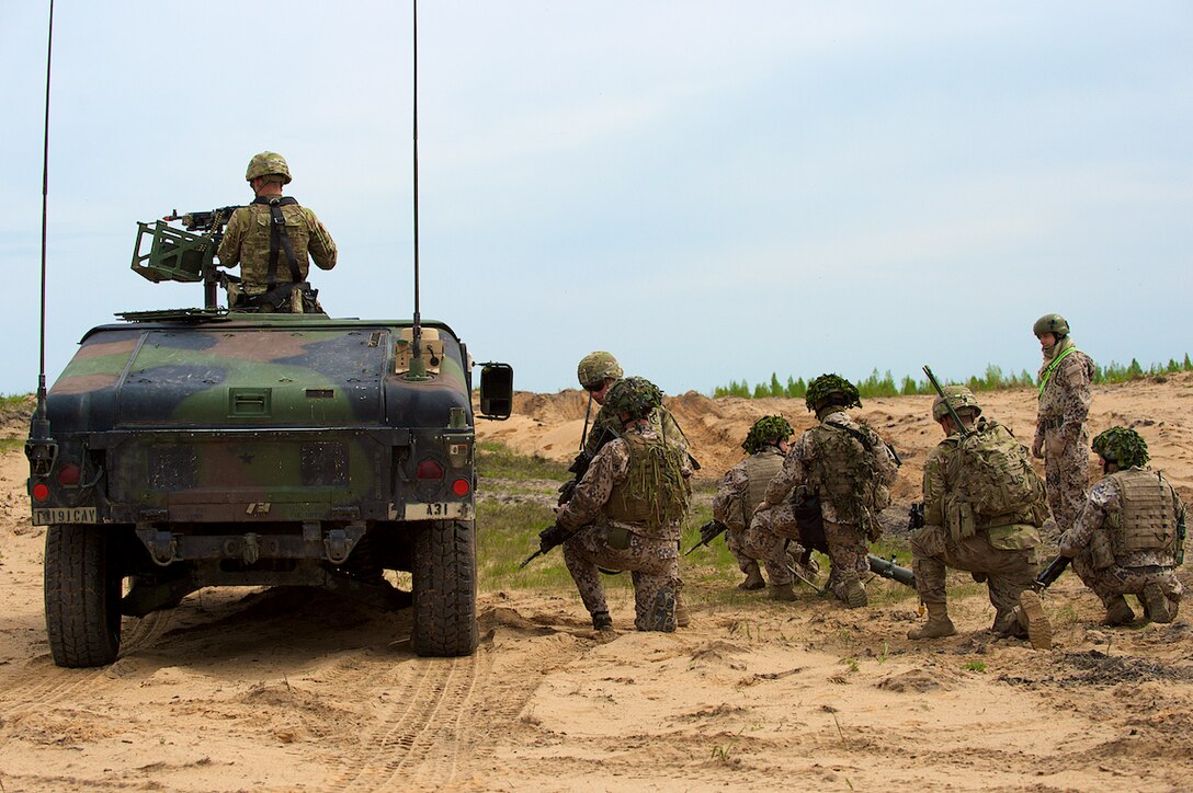 U.S. soldiers assigned to A Troop, 1st Squadron, 91st Cavalry Regiment, 173rd Airborne Brigade out of Grafenwoehr, Germany, and 1st Infantry Battalion, Latvian Land Forces Infantry Brigade prepare to conduct squad movement procedures during joint gunnery training in Adazi, Latvia, May 21, 2015. 