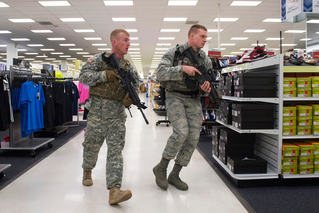 Army Sgt. Thomas Kruse, left, and Air Force Senior Airman Jerrid Wright search for an active shooter threat while conducting high risk response training at the base exchange on Joint Base Elmendorf-Richardson, Alaska, May 15, 2015. Kruse is a military policeman assigned to the 545th Military Police Company and Wright is a military policeman assigned to the 673rd Security Forces Squadron.