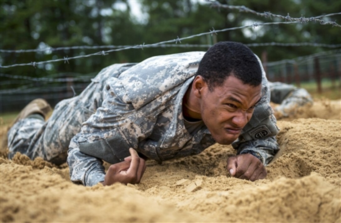 A paratrooper crawls under barbed wire as part of a team competition during All-American Week on Fort Bragg, N.C., May 19, 2015. The paratrooper is assigned to the 82nd Airborne Division. Seventeen teams from across the division negotiated nine obstacles in a race against the clock to determine the fastest team for All-American Week.