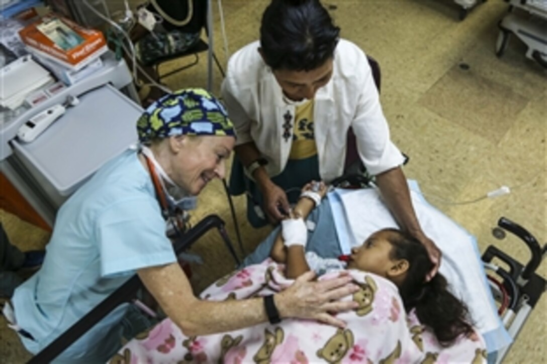 Dr. Judith Brill comforts a Nicaraguan patient in the post-operating room aboard the Military Sealift Command hospital ship USNS Comfort during Continuing Promise 2015 in the Caribbean Sea, May 18, 2015. Continuing Promise conducts civil-military operations, including humanitarian-civil assistance, subject matter expert exchanges, and medical, dental, veterinary and engineering support to partner nations. Brill is a physician volunteering with Operation Smile, a nongovernmental organization.
