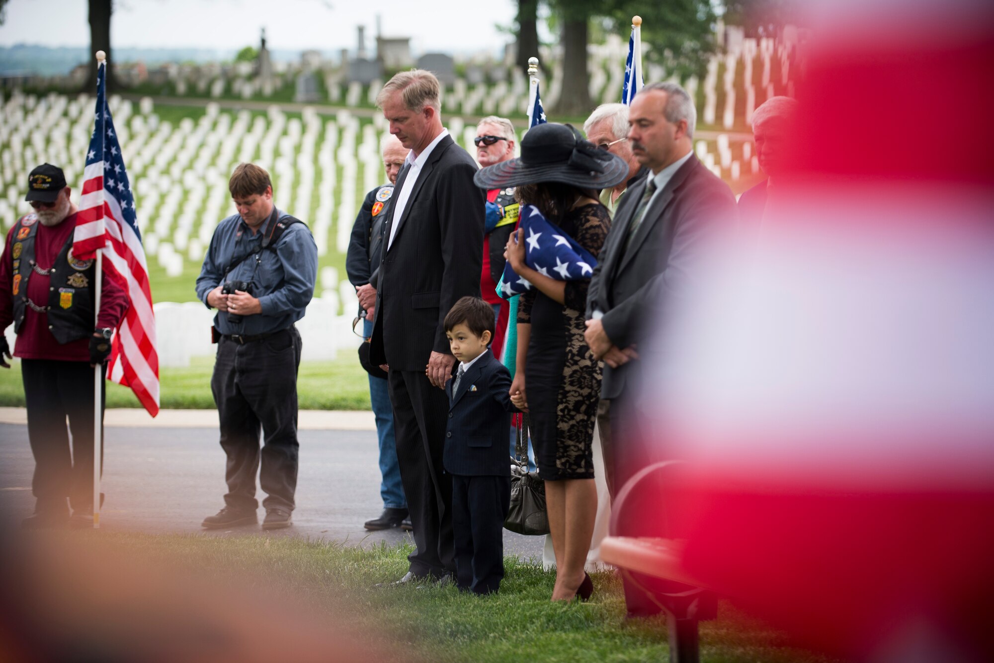 The Clever family bows their heads as Tech. Sgt. Louis Clever is brought to his final resting place, May 22, 2015, at Jefferson Barracks National Cemetery, St. Louis Missouri. Clever passed away in 1969, when his plane went down; his son Paul travelled to Laos to discover his remains. (U.S. Air Force photo by Staff Sgt. Clayton Lenhardt/Released)