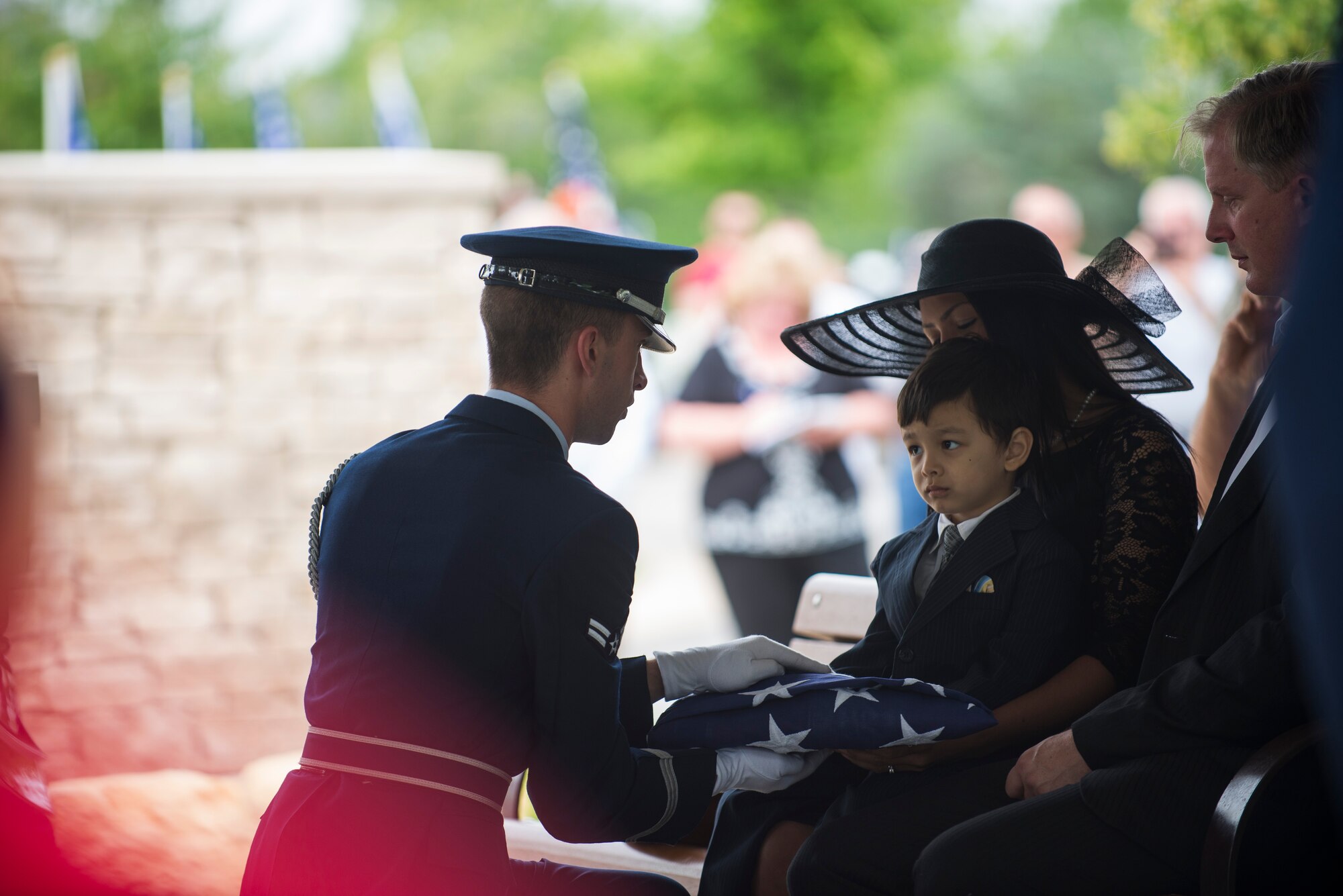 A member of Scott Air Force Base Honor Guard presents the American flag to Marcus Clever during the funeral of his grandfather, Tech. Sgt. Louis Clever, May 22, 2015, at Jefferson Barracks National Cemetery, St. Louis Missouri. Clever passed away in 1969, when his plane went down; his son Paul travelled to Laos to discover his remains. (U.S. Air Force photo by Staff Sgt. Clayton Lenhardt/Released)