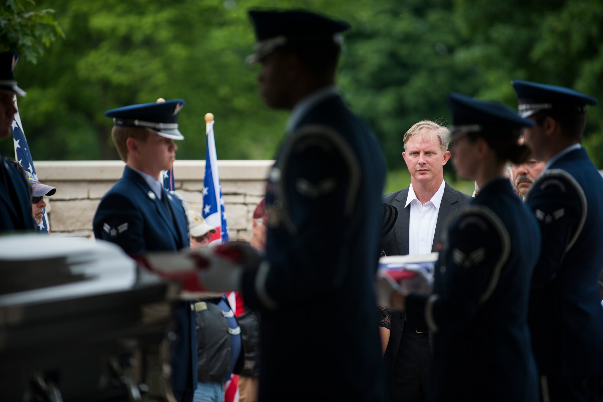 Paul Clever watches as members of Scott Air Force Base Honor Guard present the American flag during the funeral of his father, Tech. Sgt. Louis Clever, May 22, 2015, at Jefferson Barracks National Cemetery, St. Louis, Missouri. Paul travelled to Laos to find the remains of his father and hold a proper funeral for him. (U.S. Air Force photo by Staff Sgt. Clayton Lenhardt/Released)