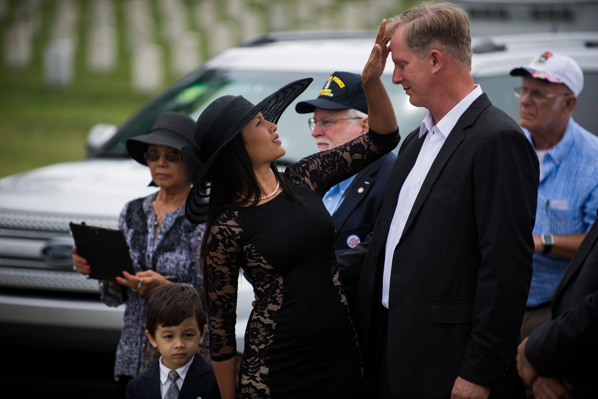 Nita Clever fixes her husband Paul's hair at the funeral of Tech. Sgt. Louis Clever May 22, 2015, at Jefferson Barracks National Cemetery, St. Louis, Missouri. Paul travelled to Laos to find the remains of his father and hold a proper funeral for him. (U.S. Air Force photo by Staff Sgt. Clayton Lenhardt/Released)