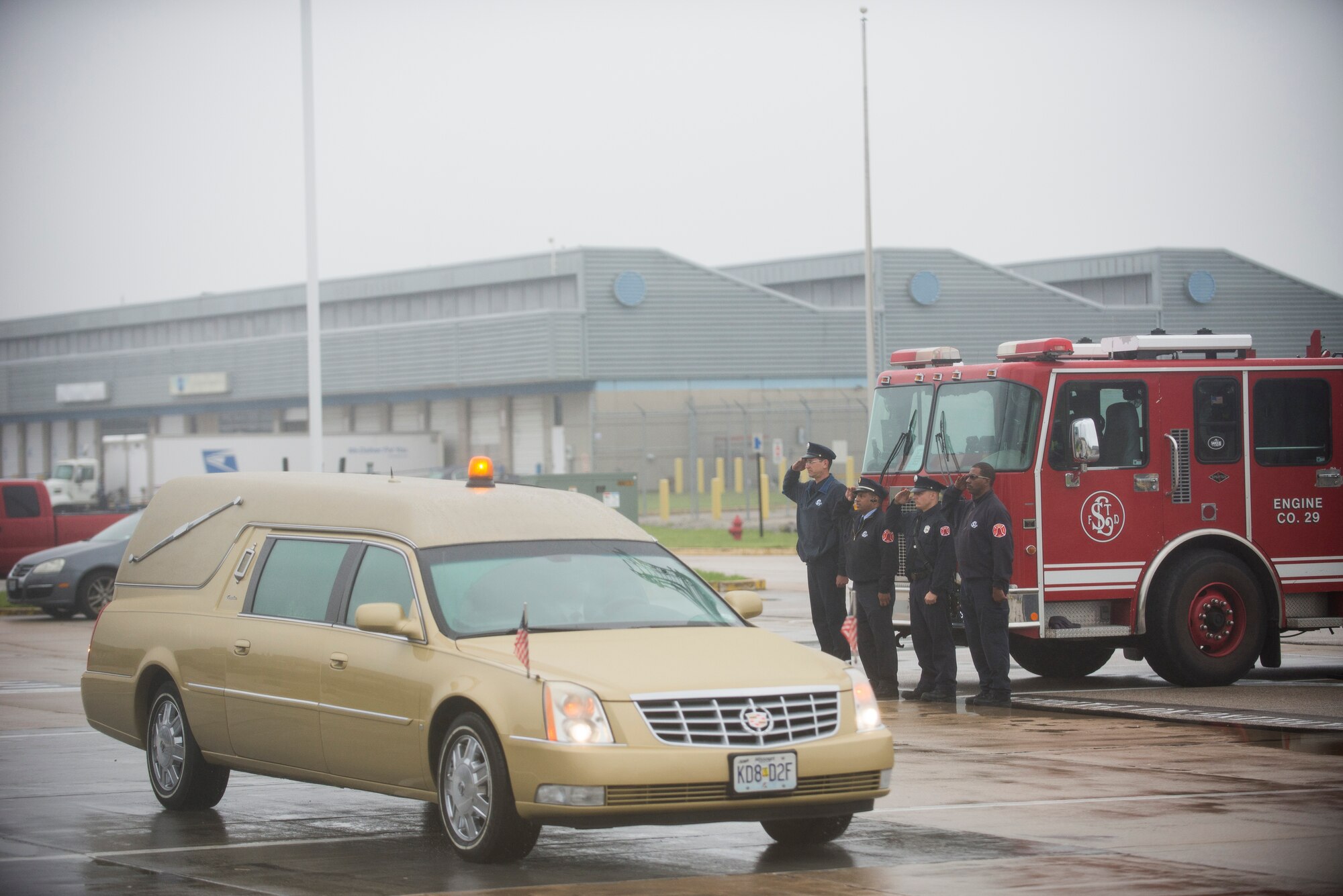 Members of the St. Louis Fire Department offer a salute as the hearse carrying Tech. Sgt. Louis Clever drives by May 20, 2015, at Lambert–St. Louis International Airport, Missouri. Clever passed when his plane went down over Laos in 1969. (U.S. Air Force photo by Staff Sgt. Clayton Lenhardt/Released)