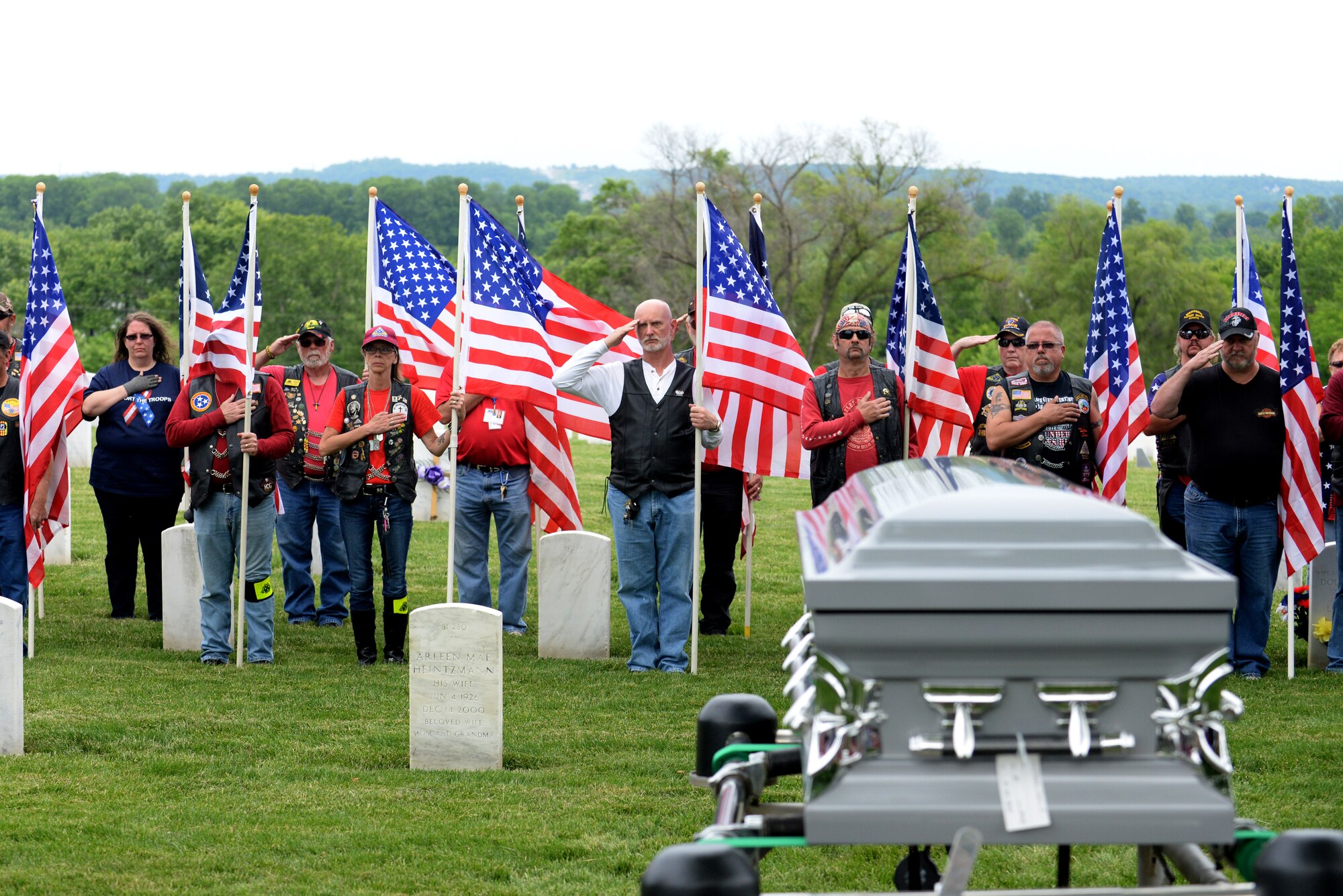 Patriot Guard Riders salute or hold their hands on their hearts to give respect to Tech. Sgt. Louis Clever at the Jefferson Barracks National Cemetery, St. Louis, Missouri, May 22, 2015. The funeral service was held more than 45 years after his death due to the remains recently being found and identified. (U.S. Air Force Photo by Airman 1st Class Megan Friedl)