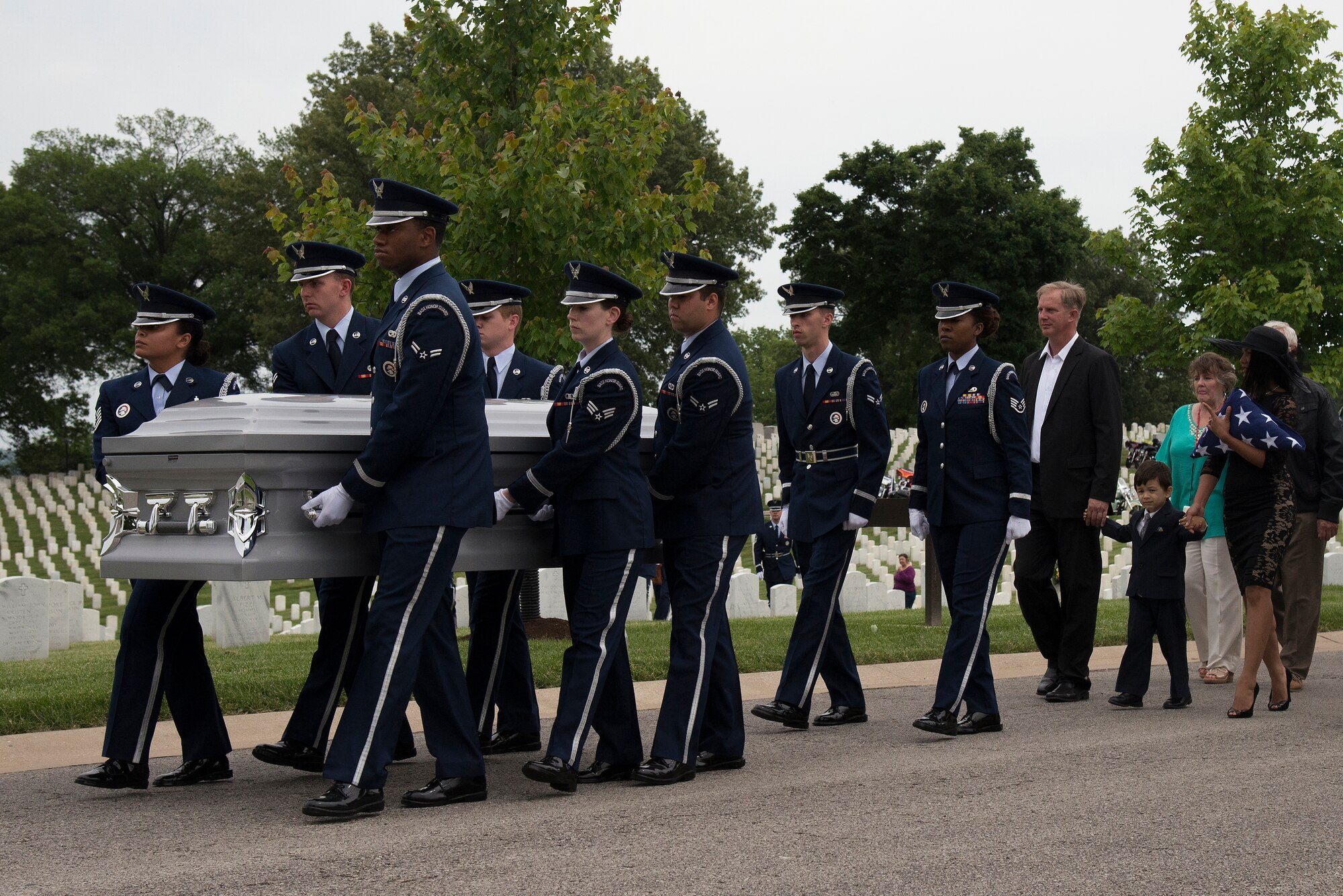 Scott Air Force Base Honorguardsmen carry the casket of Tech. Sgt. Louis Clever as family and friends follow behind at the Jefferson Barracks National Cemetery, St. Louis, Missouri May 22, 2015. Clever is a Vietnam Veteran whose remains were just recently found and identified in Southern Laos. (U.S. Air Force Photo by Airman 1st Class Megan Friedl)