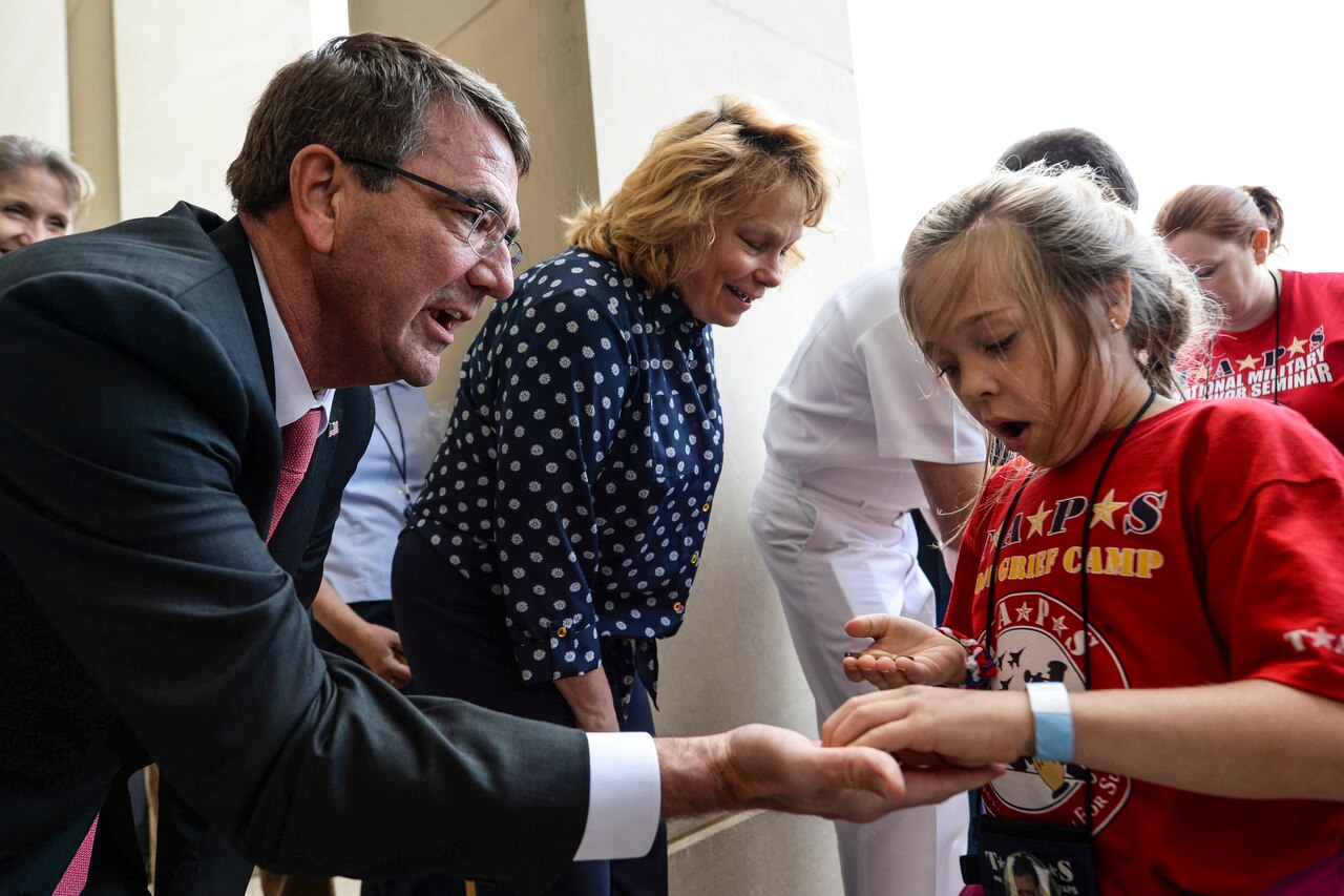 Defense Secretary Ash Carter presents challenge coins to members of the Tragedy Assistance Program for Survivors at the Pentagon, May 22, 2015. The Pentagon hosted the families for a night of fun and remembrance to mark Memorial Day. The program, known as TAPS, offers support for military families who have lost a family member serving in the military. DoD photo by Navy Petty Officer 2nd Class Sean Hurt